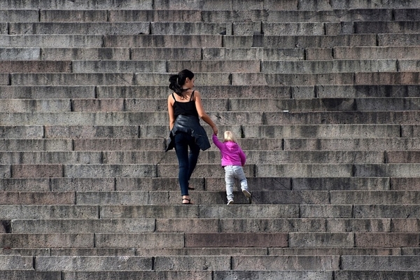 El Ingreso Mínimo Vital llegó a casi 2.300.000 personas durante el pasado mes de julio, informa el Gobierno de España Una mujer y una niña suben unas escaleras