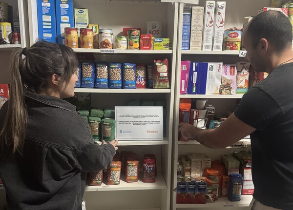 AFEDES pone en marcha una nueva edición de su proyecto para cubrir las necesidades básicas de personas en riesgo de exclusión social Dos personas ante estantes de comida envasada