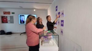 Tres mujeres observan los paneles del Museo Ultravioleta en el Castillo de Mata de Las Palmas de Gran Canaria durante la presentación de la exposición.